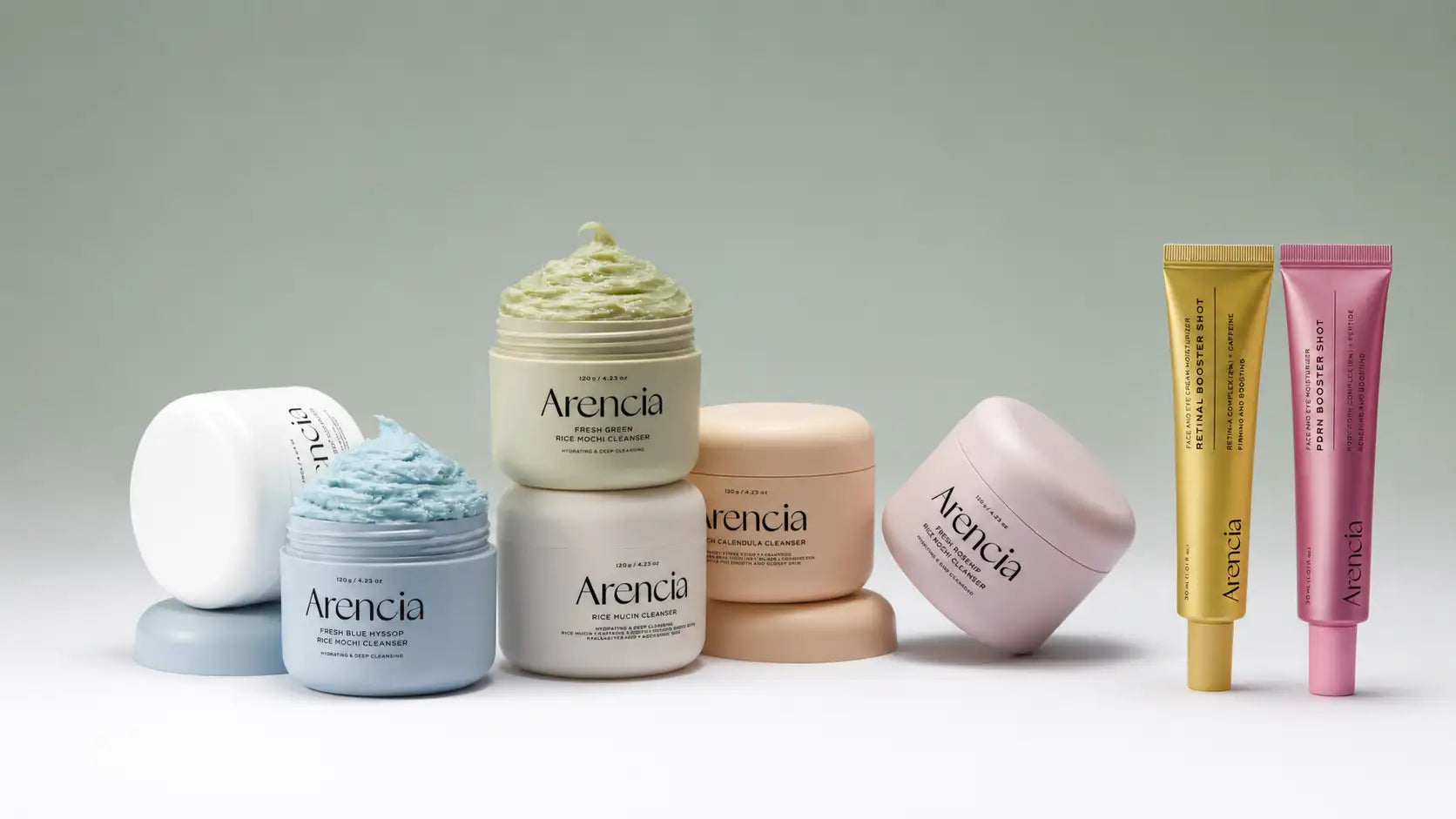 Une collection de produits de soin arencla dans des pots et tubes aux couleurs pastel, avec des textures crémeuses et une image de marque minimaliste.