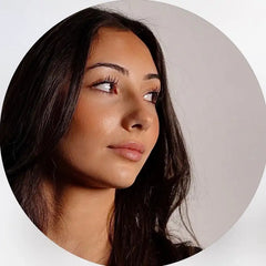 Une femme aux longs cheveux sombres et au maquillage subtil.