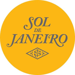 Logo circulaire jaune vif avec le texte « sol de janeiro » dans une élégante écriture grise, avec un emblème en forme de losange en dessous.