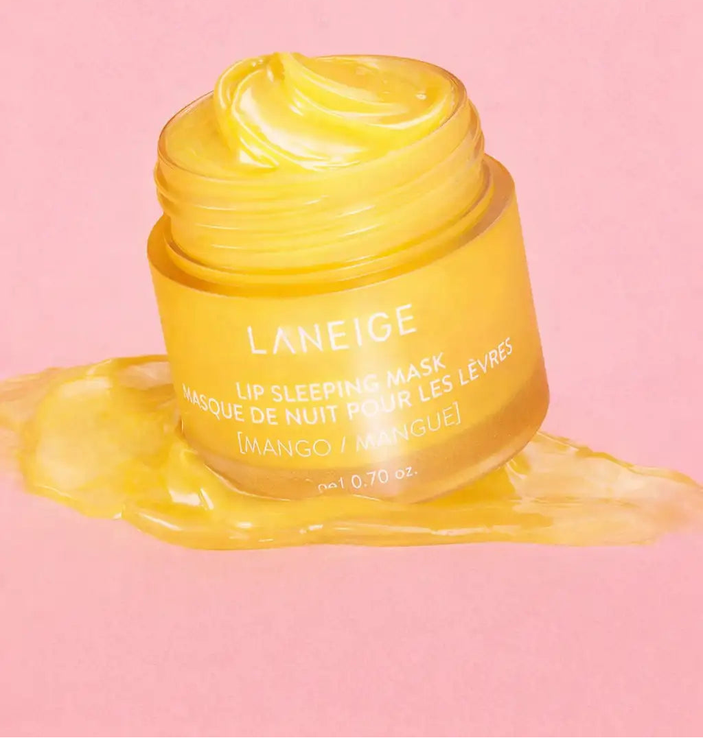 Un masque de nuit pour les lèvres à la mangue jaune vif dans un pot en verre transparent avec une étiquette blanche, présentant le nom de marque « laneige » et les détails du produit.