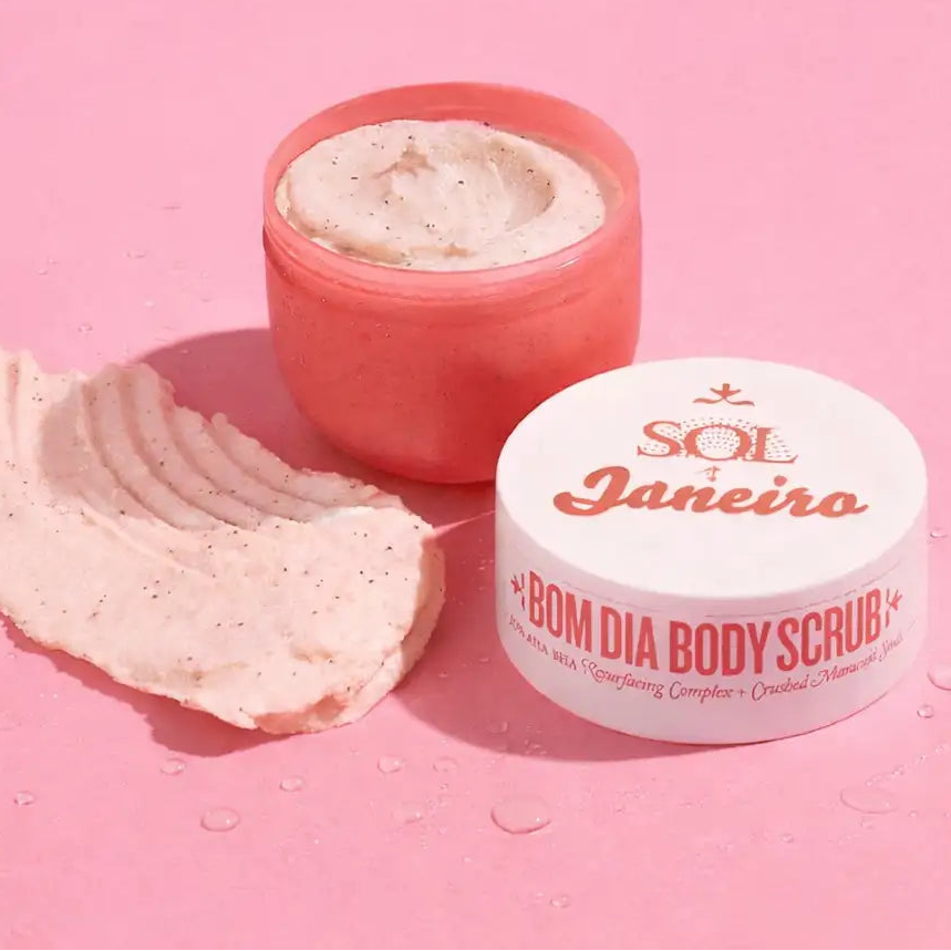Pot en corail rose avec gommage pour le corps Sol & Janeiro Bom Dia, avec un couvercle blanc et une texture crémeuse tachetée.